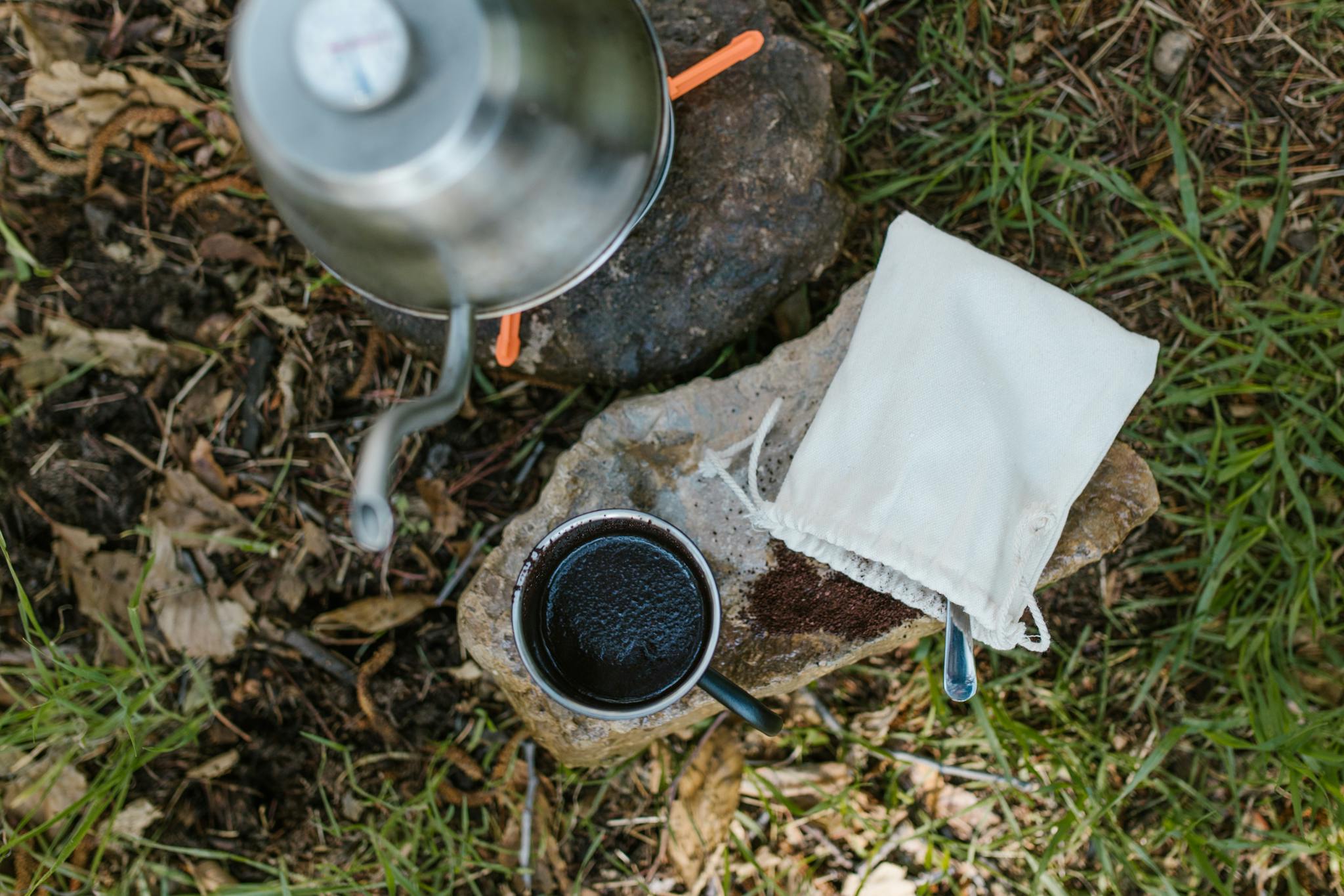 Black and Silver Round Container on Brown and Gray Stone